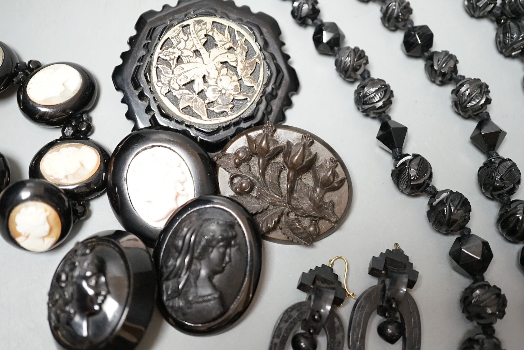 A collection of assorted jet jewellery, some with cameo, including two necklaces, five brooches, a bracelet and three pairs of earrings.